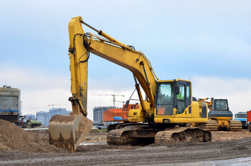 Fototapeta na wymiar Tracked excavator working at a construction site during laying or replacement of underground storm sewer pipes. Installation of water main, sanitary sewer, storm drain systems - Image