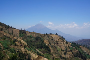 Passing the highest village in Dieng with mountain panorama.