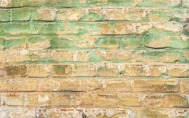 Old weathered brick wall. Peeling cracked paint on red brick
