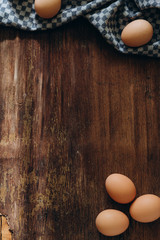 brown chicken eggs on a vintage background. On the side lies a blue linen cloth