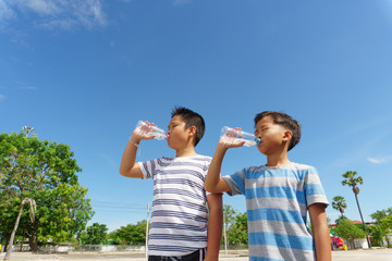 Young Asian boy drink water from bottle