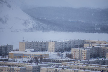 Winter industrial cityscape. View of the northern city. Cold weather, frost. Russian Arctic