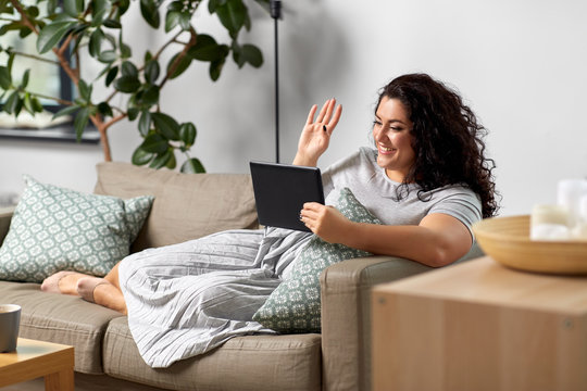 Technology, Leisure And People Concept - Happy Smiling Woman With Tablet Pc Computer Having Video Chat And Waving Hand At Home