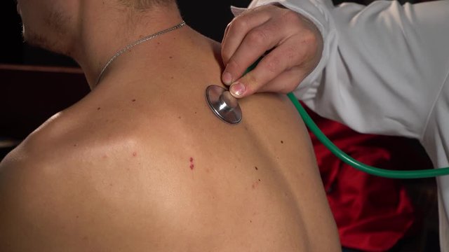 The doctor listens to the patient's lungs.Closeup of stethoscope on patient's chest