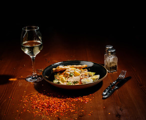 Caesar salad on black plate on wooden table