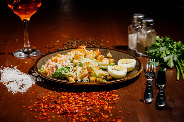 Caesar salad on black plate on wooden table