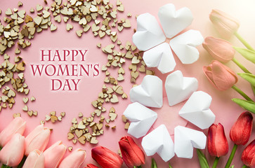 Happy Women's Day Wishes card - paper hearts shape figure eight 8 on soft pink background and bouquet of purple tulips