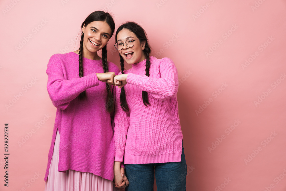 Sticker image of two young teenage girls smiling and bumping their fists together