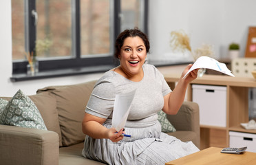 accounting, taxes and people concept - happy smiling woman with papers and calculator at home