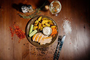 fried potatoes with meat on a plate on a wooden table.Top view