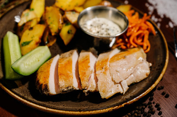 fried potatoes with meat on a plate on a wooden table