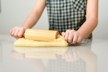 Close up kid hands prepare dough.