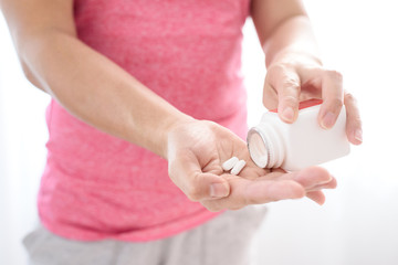 White pill on woman hand