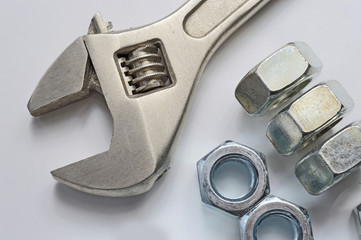screw-nut of different sizes, bolts and adjustable spanner. White background. Concept.