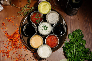 Different types of sauces and oils in bowls, top view