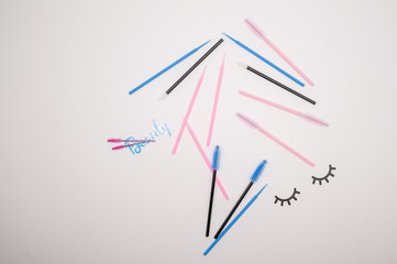 Top view on eyelash extension tools. Flatlay of multi-colored brushes for combing cilia.