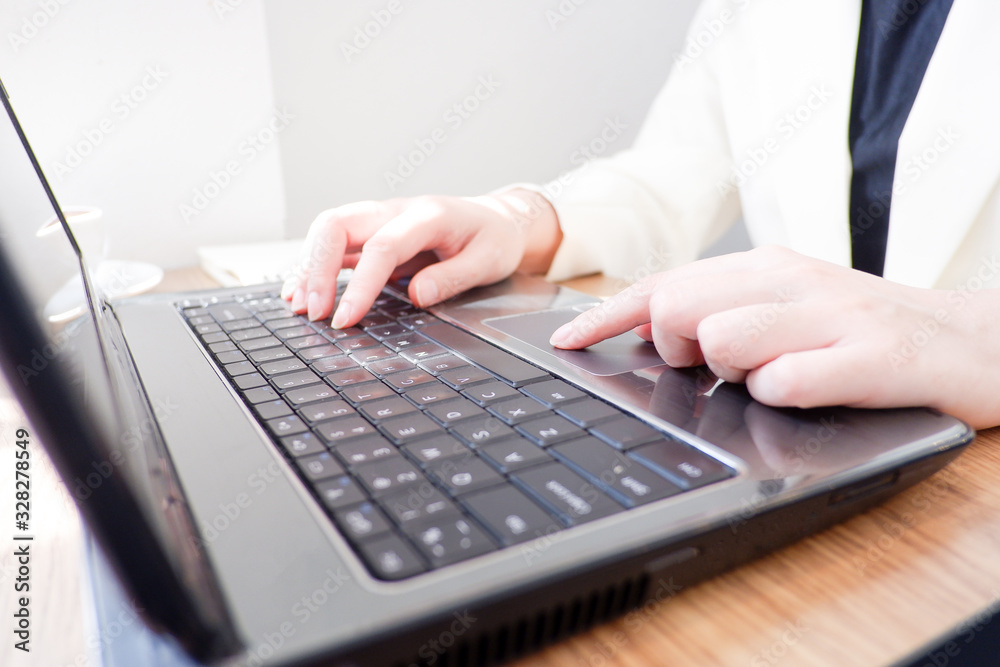 Fototapete Cropped shot view of business woman’s hands typing the labtop with blank copy space screen for your information content or text message