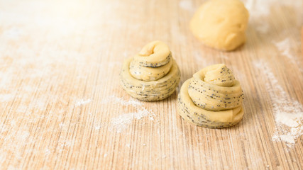 raw cruffins before baking in the oven. puff pastry croissant similar to a muffin with poppy seeds. modern baking. close-up, space for text. the horizontal frame.