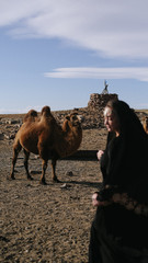 beautiful woman national eastern clothes black color,veil,hijab,abaya ornament her head,portrait steppes camels,strong wind,desert,wildlife,well,decoration,caucasian,slow ,sun