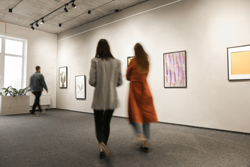 Exhibition in modern crowded art gallery