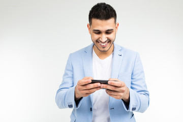 portrait of a brunet businessman in a stylish jacket watching video on a smartphone on a white background