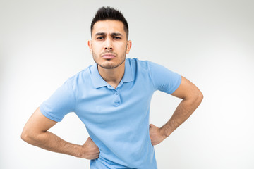 Caucasian handsome guy in a blue T-shirt stood in a pose and is not inferior on a white studio background