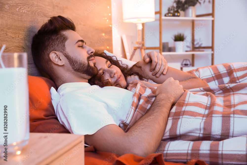 Sticker Happy young couple lying in bed at night