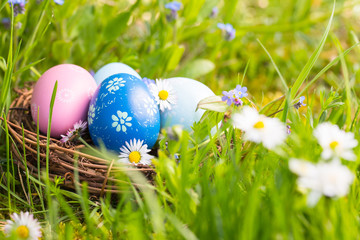Happy Easter  -  Nest with easter eggs in grass on a sunny spring day - Easter decoration background - 328283599