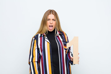young pretty blonde woman angry, anger, disagreement, holding a number 1.