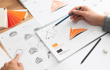 Graphic designer drawing sketches logo design.