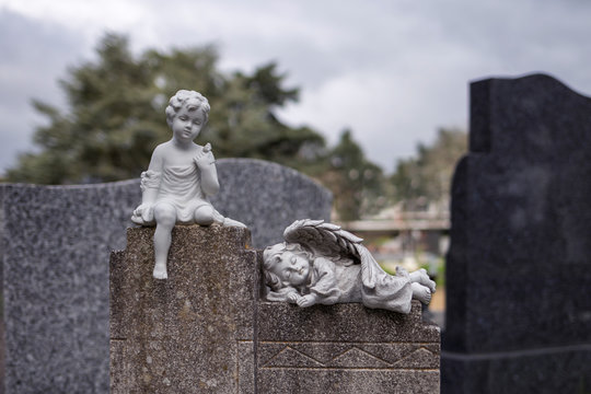 two angel on grave tomb, graveyard, child statue by a grave
