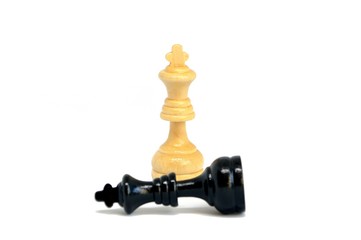 The white king defeated black king  isolated on white background. Blurred black king