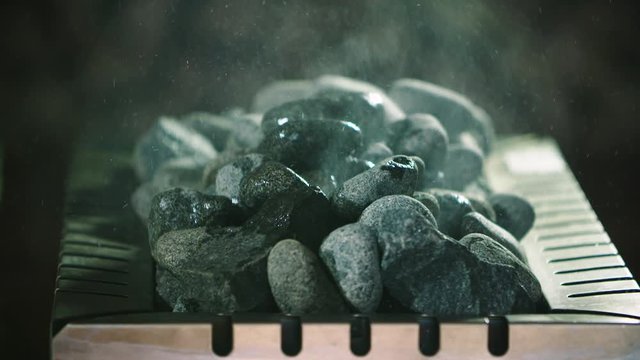 Slow Motion Close Up Shot Of A Wet Sauna. Splash Water On Hot Flaming Stones