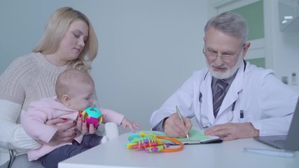 Young woman visiting doctor with baby for regular health checkup, medicine