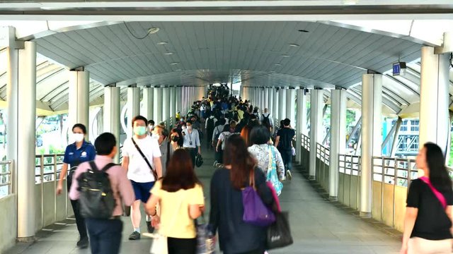 Time lapse a Lots of people in public skywalk Chong Nonsi for transit between sky train in bangkok downtown square in business zone in evening rush hour