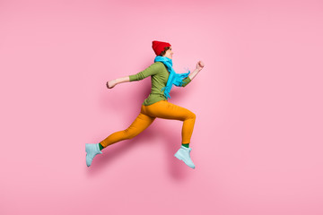 Fototapeta na wymiar Full size profile side photo of cheerful charming girl jump up run after spring time discounts wear shoes red blue sweater pants headwear isolated over pink color background