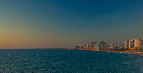 Obraz premium Tel Aviv capital of Israel hige beautiful city waterfront Mediterranean area landmark and landscape view skyscraper building and sea water in twilight evening sunset lighting, copy space