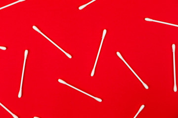 Flat lay composition with cotton swabs on red background. Top view ear sticks