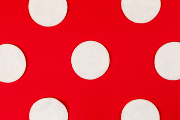 Pattern of cotton pads with hard shadows on a red background