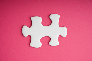 White jigsaw puzzle pieces on pink background. Copy space