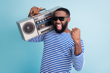Photo of funny dark skin guy hold retro cassette recorder on shoulder raise fist amazing students...