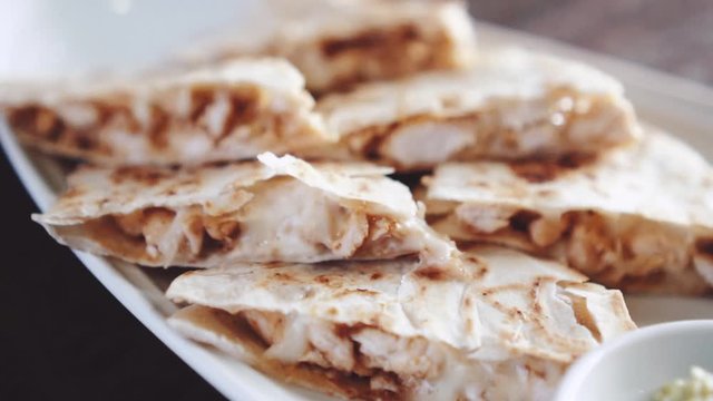 Closeup of slliced chicken quesadilla  - video in slow motion