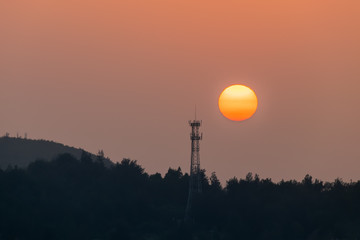 The setting sun falls on the tower crane at the construction site