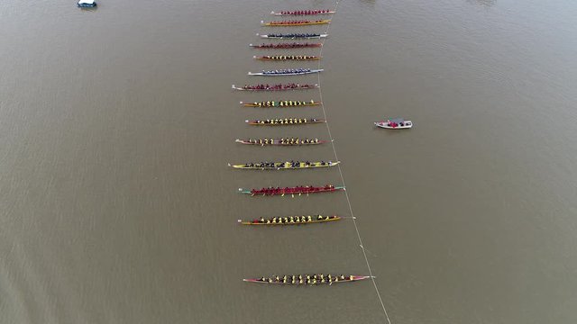 rowing boat race for 16 boats with 30 rowers during challenge title of river king regatta festival.	
