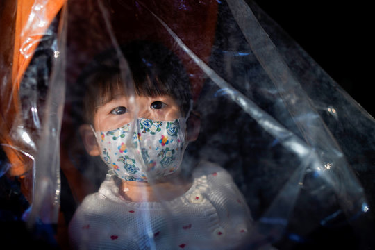 A baby wearing a face mask inside a stroller is seen as the country is hit by an outbreak of the novel coronavirus, in Shanghai