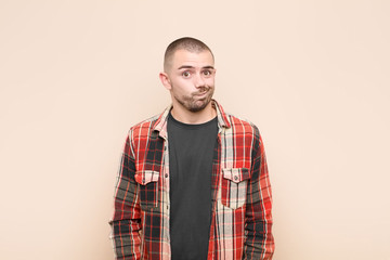 young handsome man feeling confused and doubtful, wondering or trying to choose or make a decision...