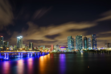 Fototapeta premium Miami city skyline panorama at dusk with urban skyscrapers and bridge over sea with reflection