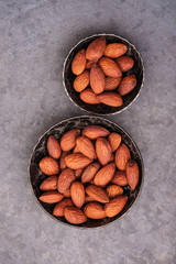 almonds in two bowls on gray backgrounds