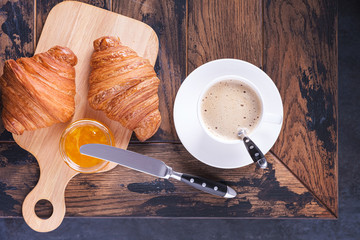 Сroissant and orange jam on table