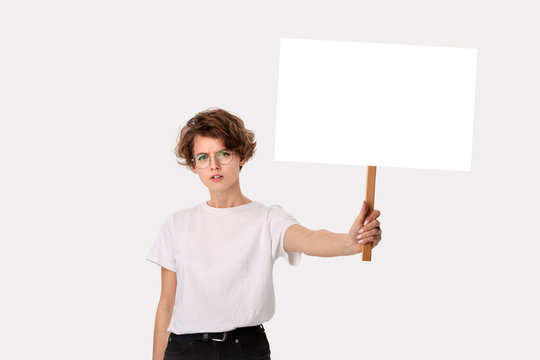 Concerned female protester holding empty signboard with copy space.